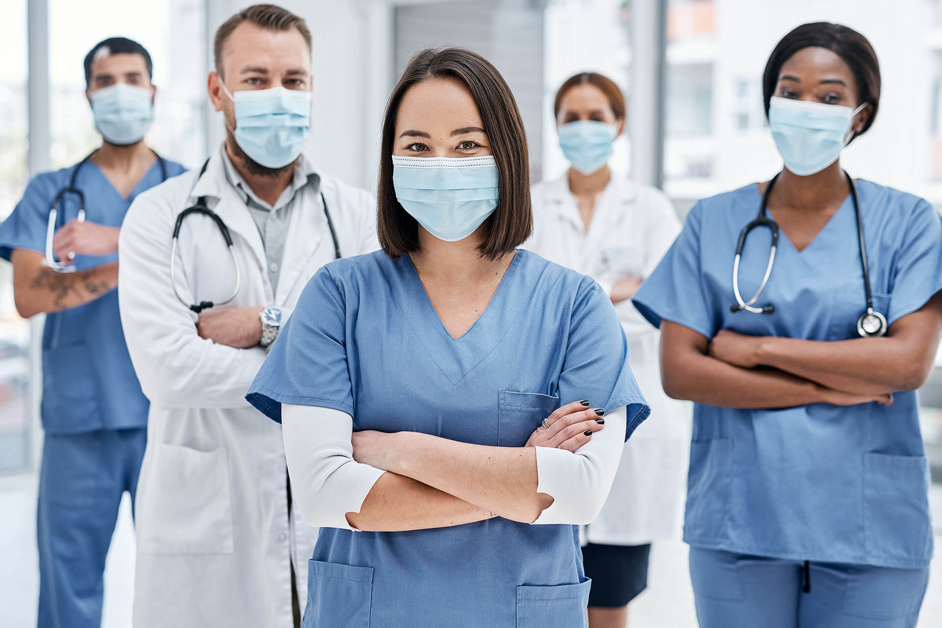 Group of racially diverse healthcare workers standing together wearing masks
