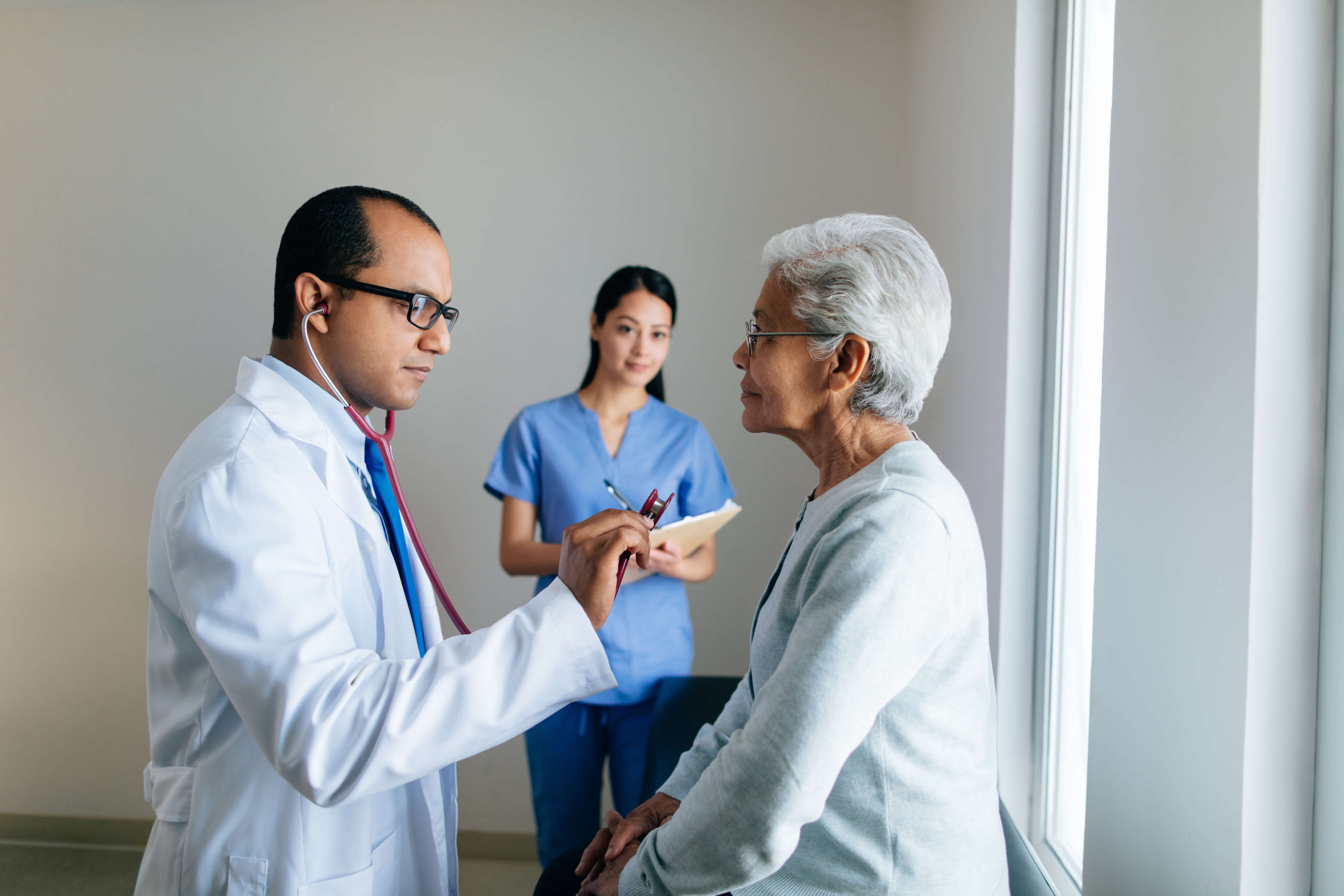 Male doctor consulting patient with Physician Assistant