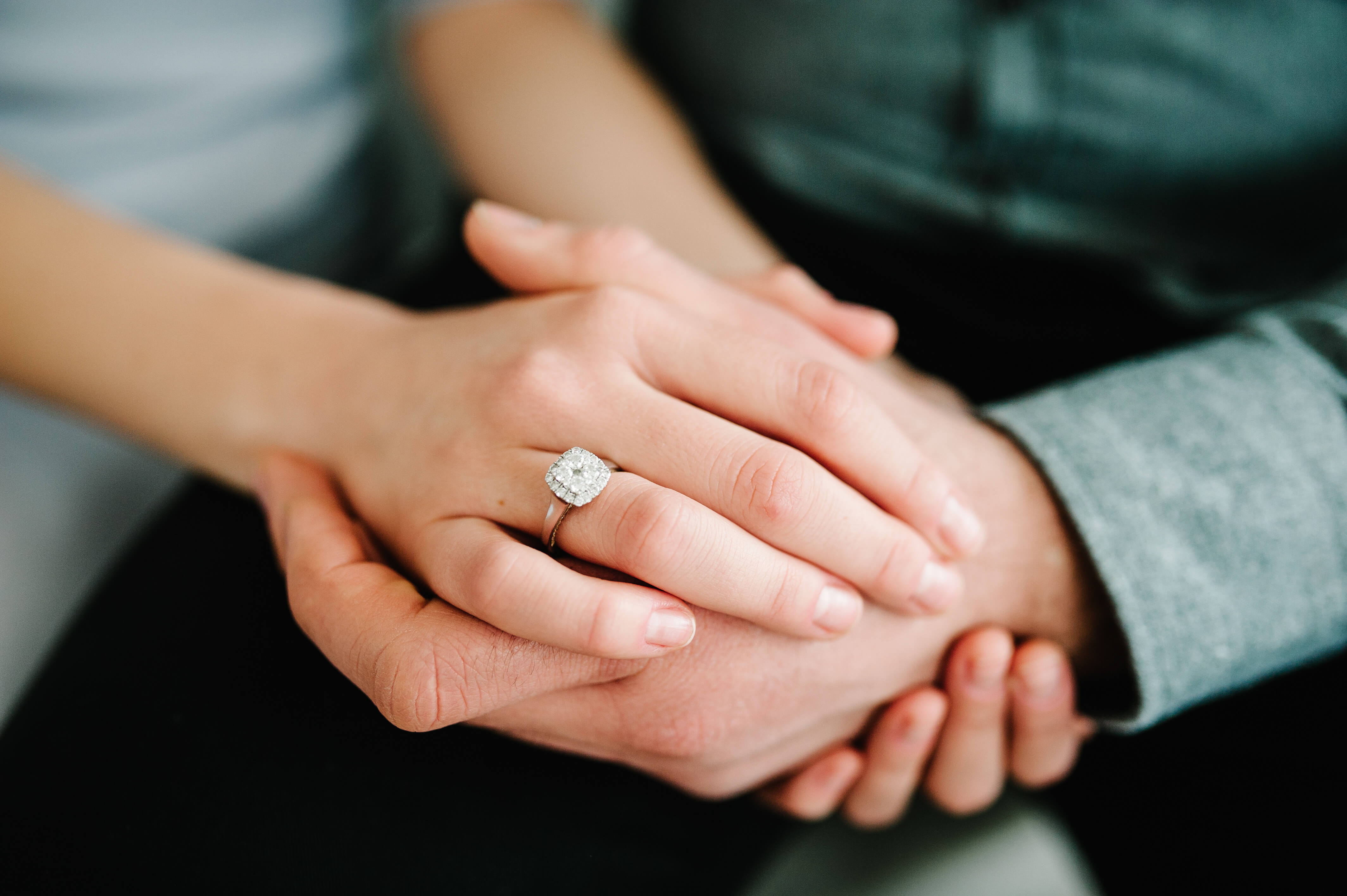 Couple holding hands wearing wedding ring